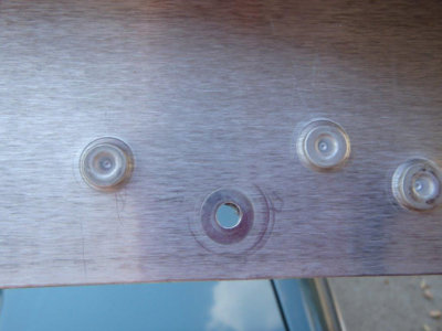 Rivets become the primary mechanism during a crash event when the adhesive would normally peel.